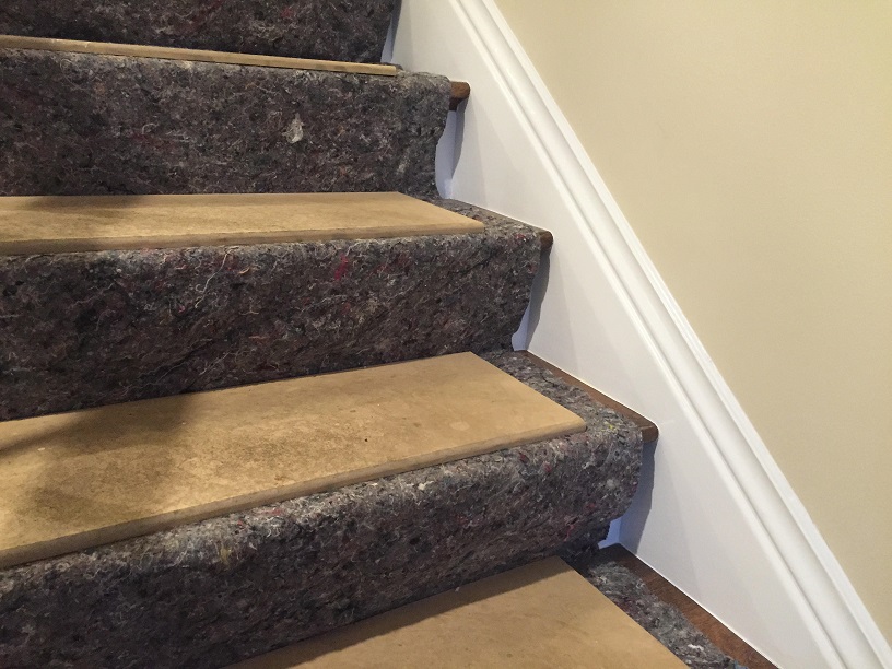Stairs covered with MDF boards and fabric for protection at a job site, solving a common remodeler dilemma.