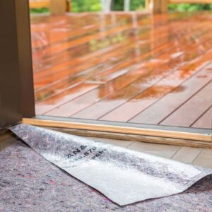 Clean&Safe® reusable floor protector by open door, ensuring skid-resistant and leak-proof surface protection.