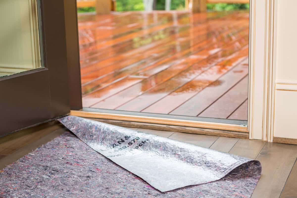 Clean&Safe® reusable floor protector by open door, ensuring skid-resistant and leak-proof surface protection.